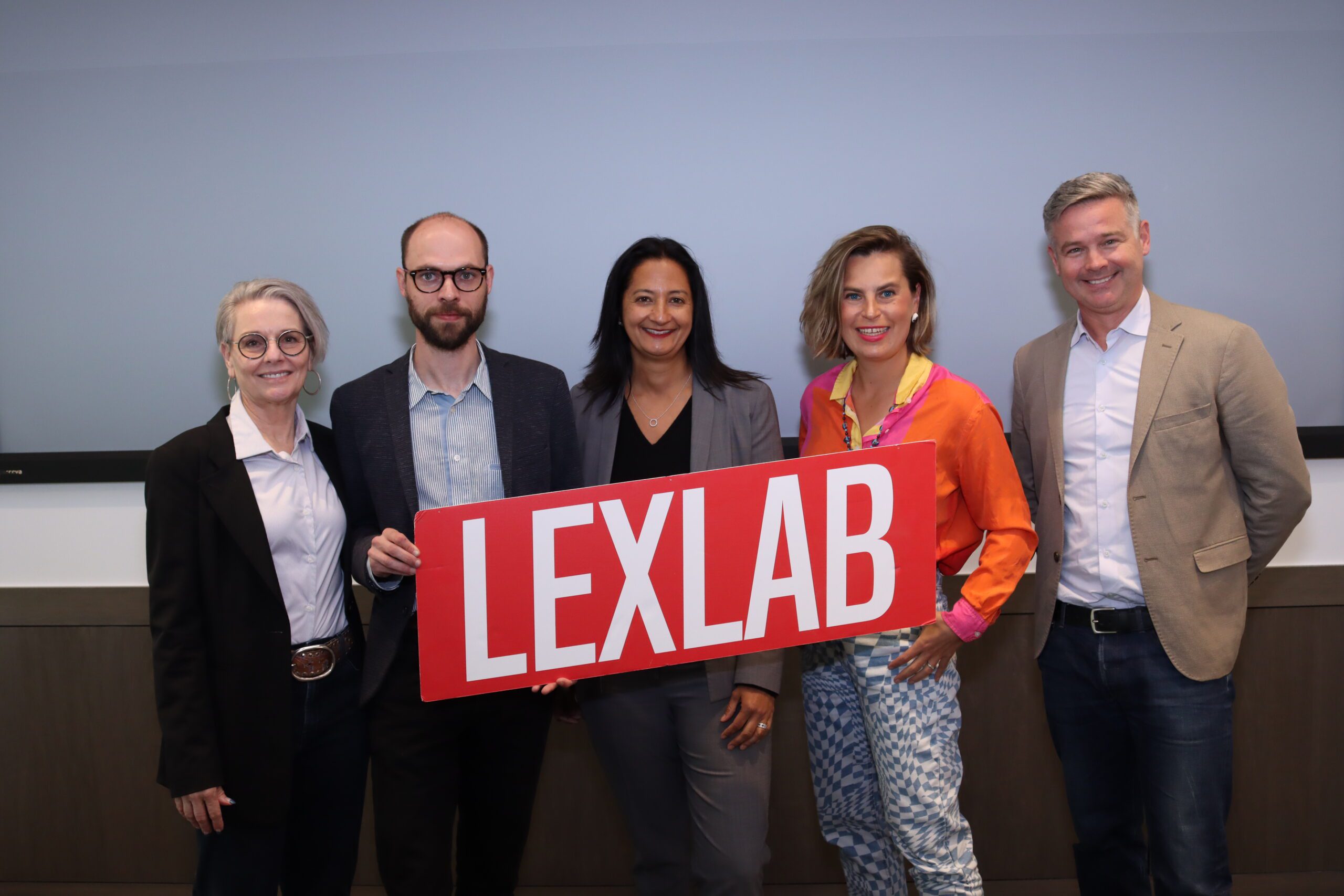 Professors and legal technology entrepreneuers pose with a UC Hastings LexLab sign