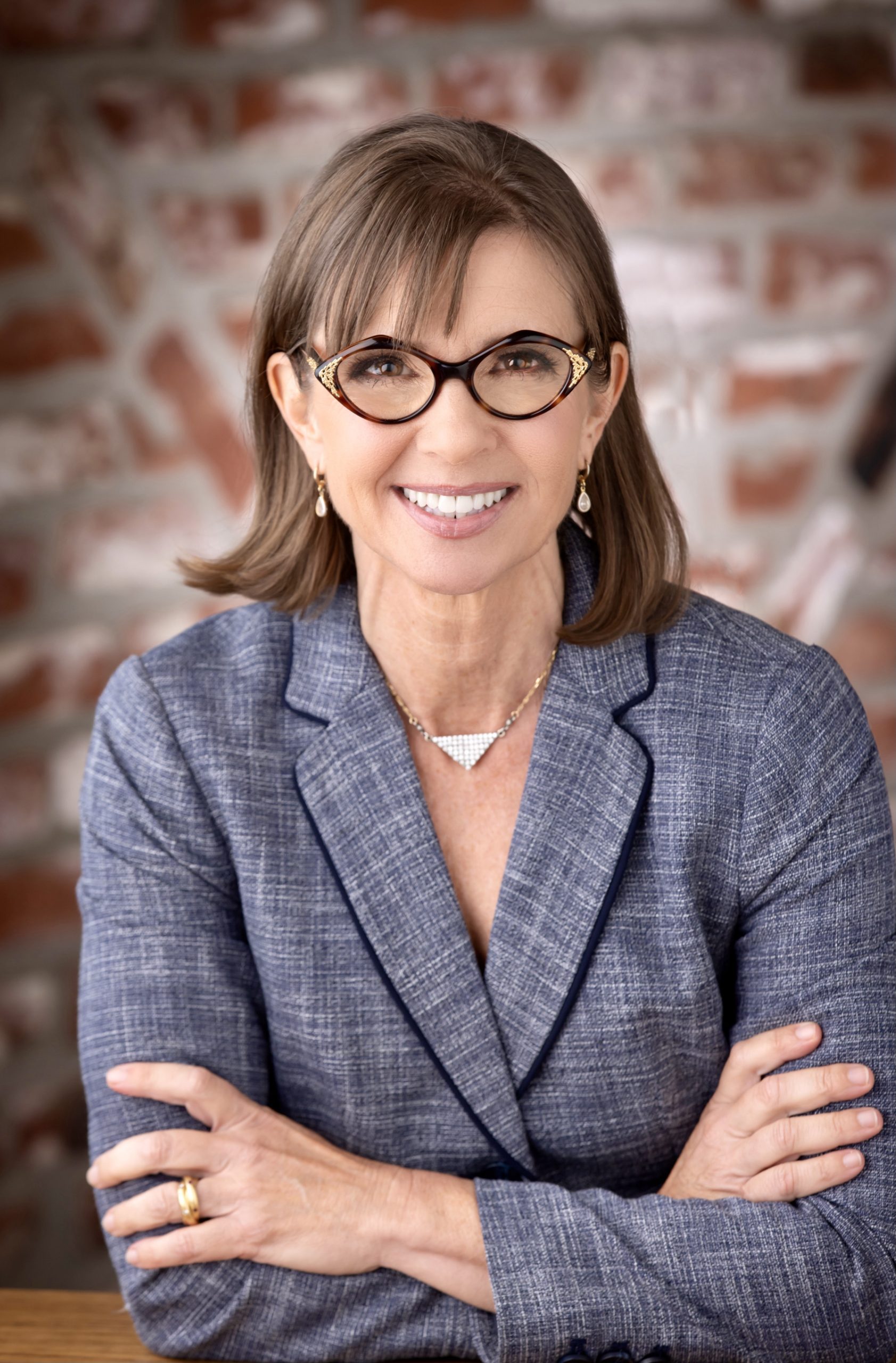 woman folded arms in professional suit and glasses