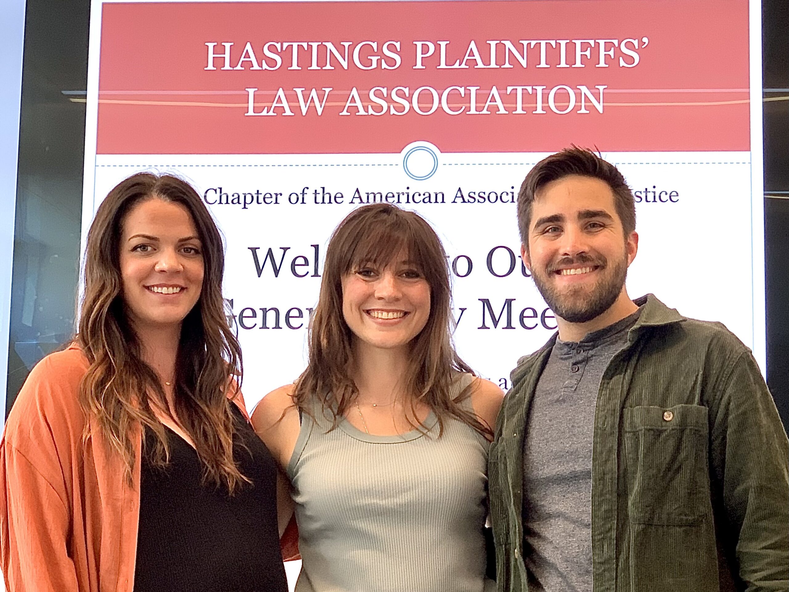 Three law students (two female, one male) pose and smile smile